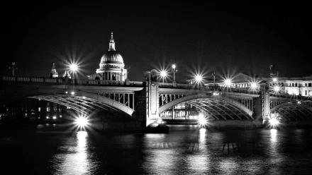 Black and white HD desktop wallpaper of London’s Southwark Bridge illuminated at night with St. Paul’s Cathedral in the background.