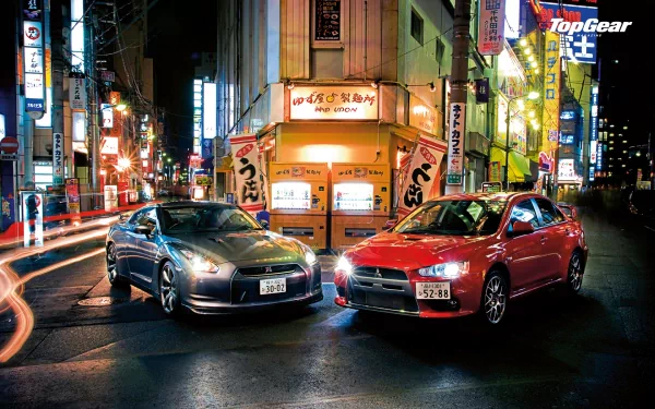 HD desktop wallpaper of two cars on a vibrant city street at night with Top Gear logo.