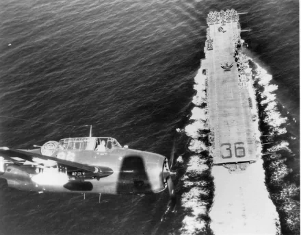 Black-and-white HD PC desktop wallpaper: aerial view of United States Navy aircraft carrier USS Antietam (CV-36), deck marked 36, with a military aircraft flying alongside.