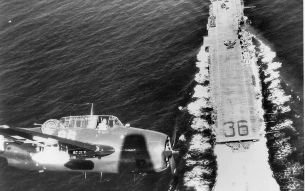 Black-and-white HD PC desktop wallpaper: aerial view of United States Navy aircraft carrier USS Antietam (CV-36), deck marked 36, with a military aircraft flying alongside.