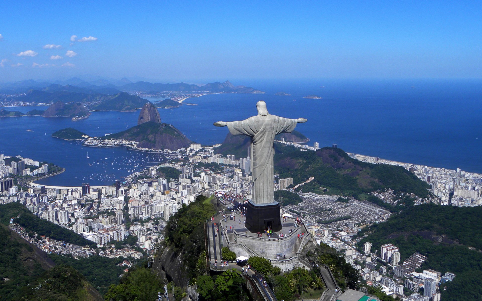 2K PC wallpaper of the man-made Christ the Redeemer on Corcovado, overlooking Rio de Janeiro, Brazil with cityscape, Sugarloaf and Atlantic Ocean.