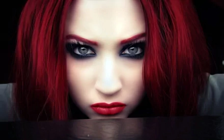A striking woman with bold red hair, intense gaze, and dramatic makeup stares directly at the viewer, creating an impactful HD desktop wallpaper.