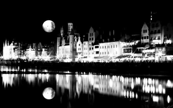 Black and white 4K Ultra HD photograph of Gdansk city at night, showcasing illuminated historic buildings and their reflections under a bright full moon.