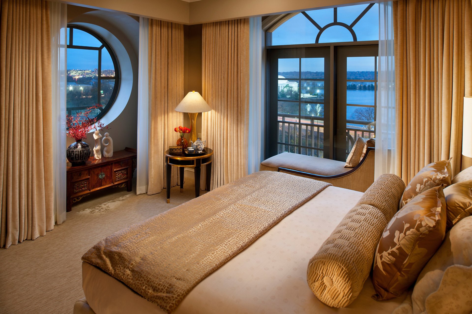 Man-made elegant bedroom with large windows, beige curtains, a comfortable bed, and scenic outdoor views, captured as an HD PC desktop wallpaper and background.