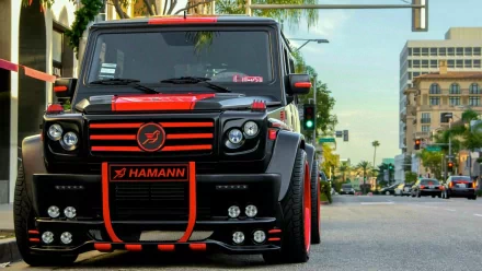 A striking Mercedes-Benz G-Class with a bold black and red design parked on a city street, showcasing its powerful presence and sleek styling in this HD desktop wallpaper.