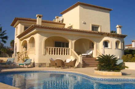 HD PC desktop wallpaper background: sunlit Mediterranean-style man-made villa with arched terrace, tiled roof and a clear blue swimming pool.