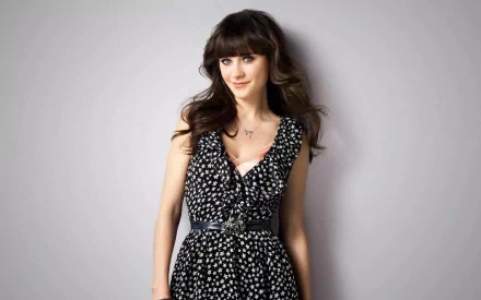 HD wallpaper featuring Zooey Deschanel, showcasing her in a stylish polka dot dress against a simple background, capturing her charming personality and elegance.