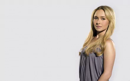HD PC desktop wallpaper featuring celebrity Hayden Panettiere standing against a plain light background, wearing a sleeveless gray top.
