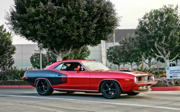 Red and black Plymouth Barracuda muscle car parked on a city street under trees — HD PC desktop wallpaper and background of a classic vehicle.