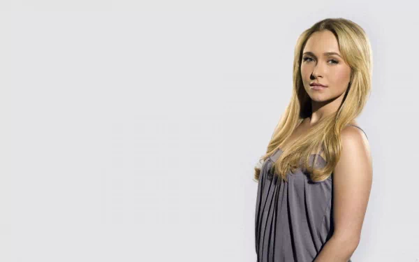 HD PC desktop wallpaper featuring celebrity Hayden Panettiere standing against a plain light background, wearing a sleeveless gray top.
