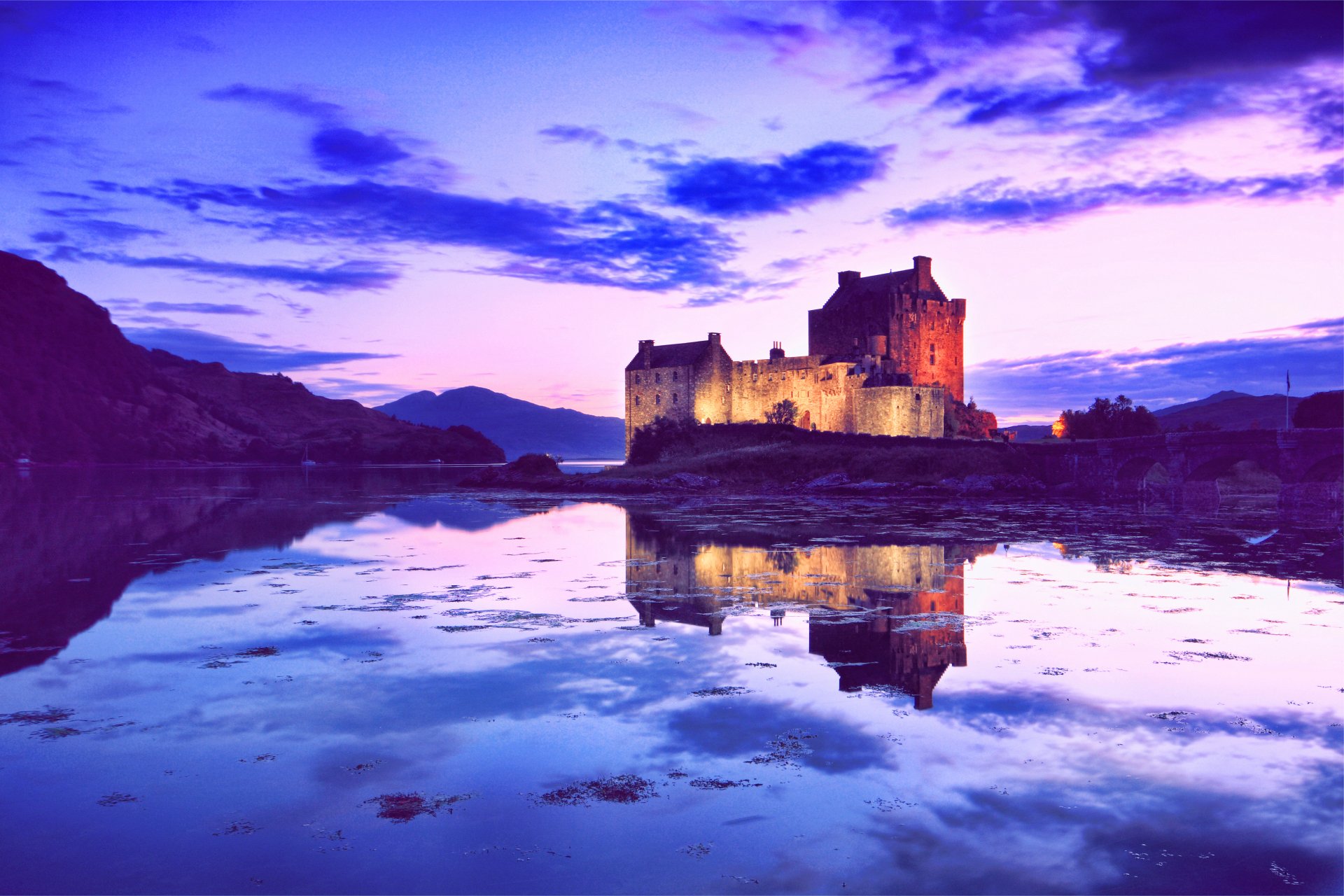 4K Ultra HD photography capturing a serene castle illuminated at dusk, mirrored perfectly in the calm water, creating a stunning reflection for a PC desktop background.