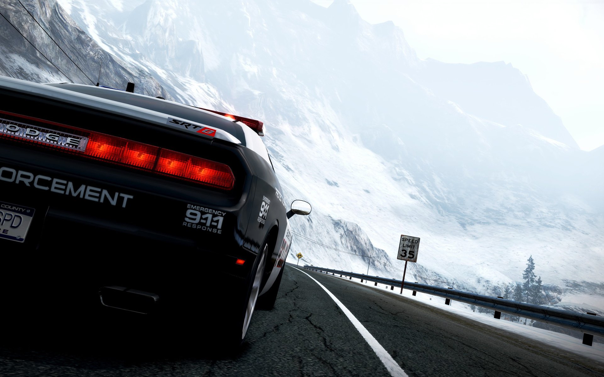 HD PC desktop wallpaper: rear three-quarter view of a Dodge Challenger SRT enforcement vehicle roaring down a snowy mountain highway.
