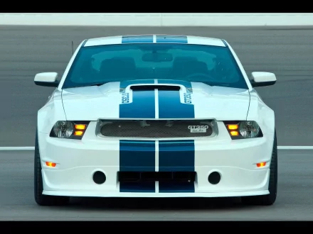 Front view of a white Ford Mustang Shelby with blue racing stripes on a racetrack, featured as an HD PC desktop wallpaper and background.