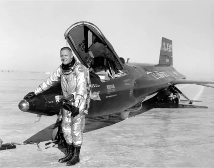 Neil Armstrong in a silver flight suit stands beside the NASA North American X-15 military aircraft, captured in a high-definition black-and-white desktop wallpaper.