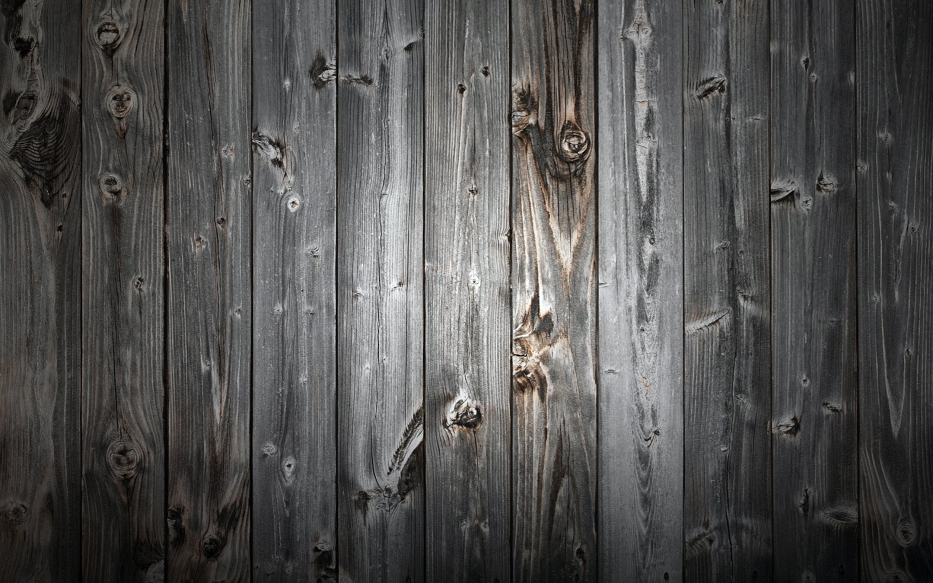 Artistic HD PC desktop wallpaper featuring dark, textured wooden planks with visible knots and grain details, creating a rustic and natural background.