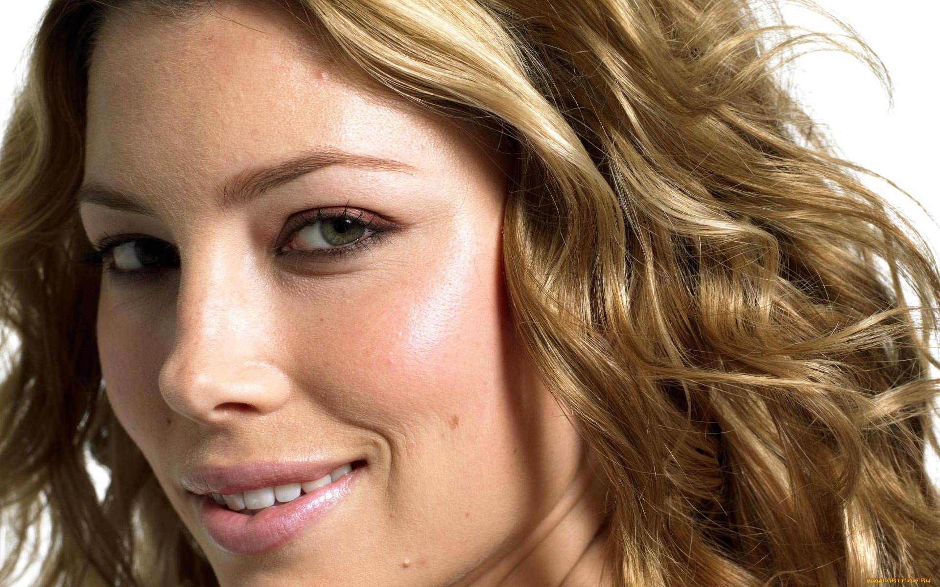 HD PC desktop wallpaper featuring a close-up portrait of celebrity Jessica Biel with wavy blonde hair and a subtle smile against a light background.