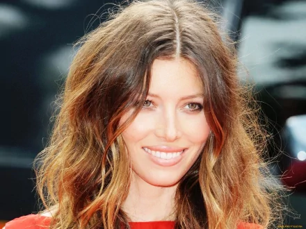 HD desktop wallpaper featuring a close-up of celebrity Jessica Biel smiling with wavy hair and natural makeup.