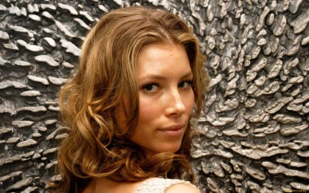 HD PC desktop wallpaper featuring celebrity Jessica Biel with softly curled hair against a textured, metallic silver background.