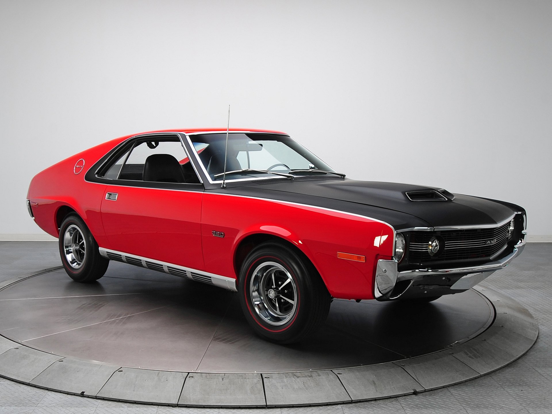 HD desktop wallpaper featuring a vibrant red 1970 AMC AMX muscle car against a plain background.