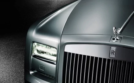 HD PC desktop wallpaper: close-up of a silver Rolls-Royce Phantom luxury vehicle front, showing the Spirit of Ecstasy hood ornament, headlight and chrome grille.