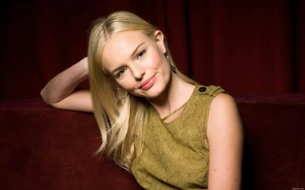 HD desktop wallpaper featuring celebrity Kate Bosworth with blonde hair, wearing a sleeveless olive top, posing against a dark red background.