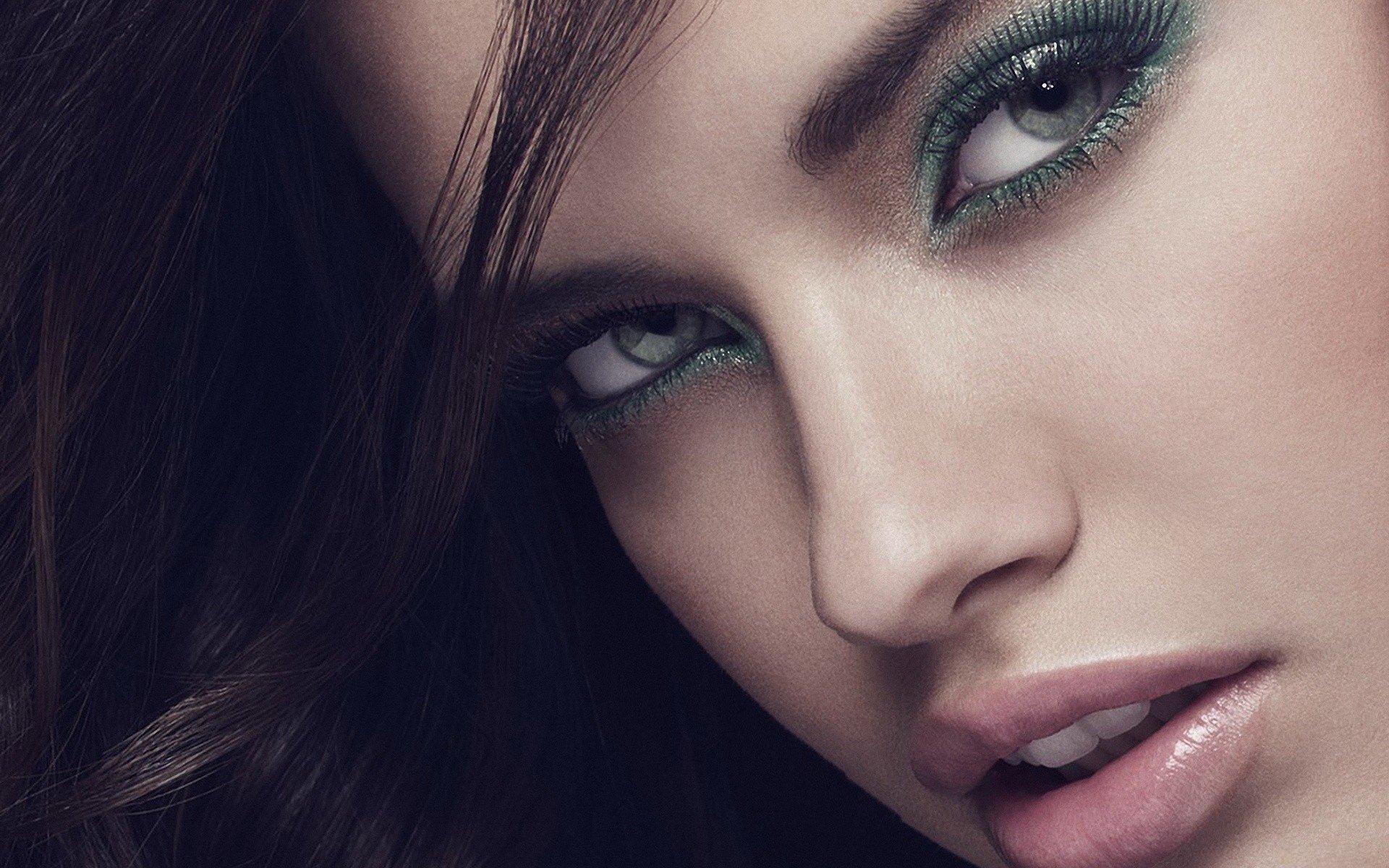 Close-up HD desktop wallpaper of celebrity Adriana Lima with striking green eye makeup and glossy lips.