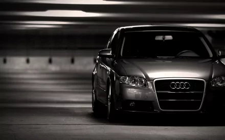 A sleek Audi A4 parked in a dimly lit garage, captured in high definition, providing a striking contrast between the vehicle and its surroundings.