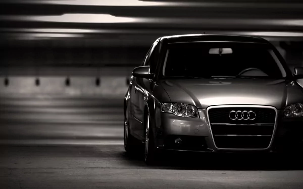 A sleek Audi A4 parked in a dimly lit garage, captured in high definition, providing a striking contrast between the vehicle and its surroundings.