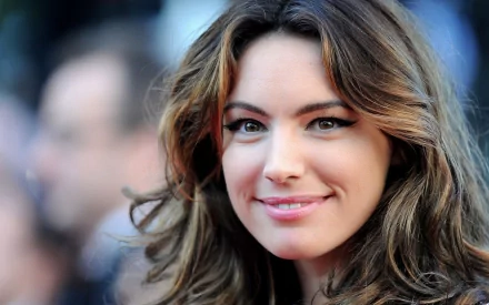 HD PC desktop wallpaper featuring a close-up portrait of celebrity Kelly Brook smiling with soft lighting and a blurred background.
