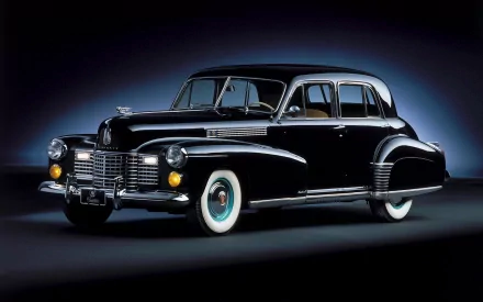 A sleek black 1941 Cadillac Sixty Special showcased in an HD desktop wallpaper, highlighting its classic design and whitewall tires against a dark background.