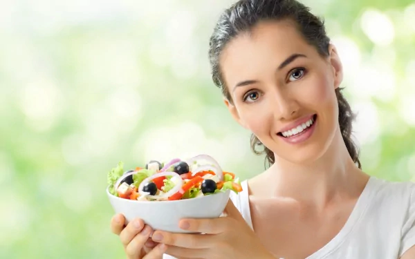 A smiling woman holding a colorful bowl of fresh salad, captured in vibrant detail for a 4K Ultra HD PC desktop wallpaper.