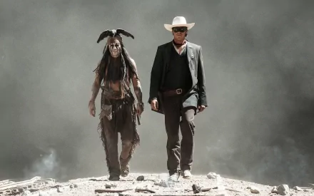 Armie Hammer as Tonto and Johnny Depp as the Lone Ranger walk together through a dramatic, smoky landscape in this HD desktop wallpaper from The Lone Ranger.