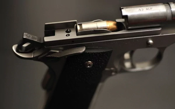Close-up of a Kimber pistol, showcasing its sleek design and ammunition chambered for action. This high-definition image makes for a striking desktop wallpaper or background.