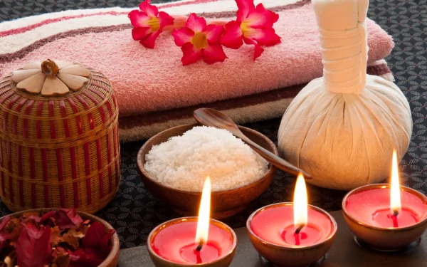 4K Ultra HD desktop wallpaper featuring a man-made spa setup with candles, bath salts, a herbal compress, and flowers arranged on a woven mat.