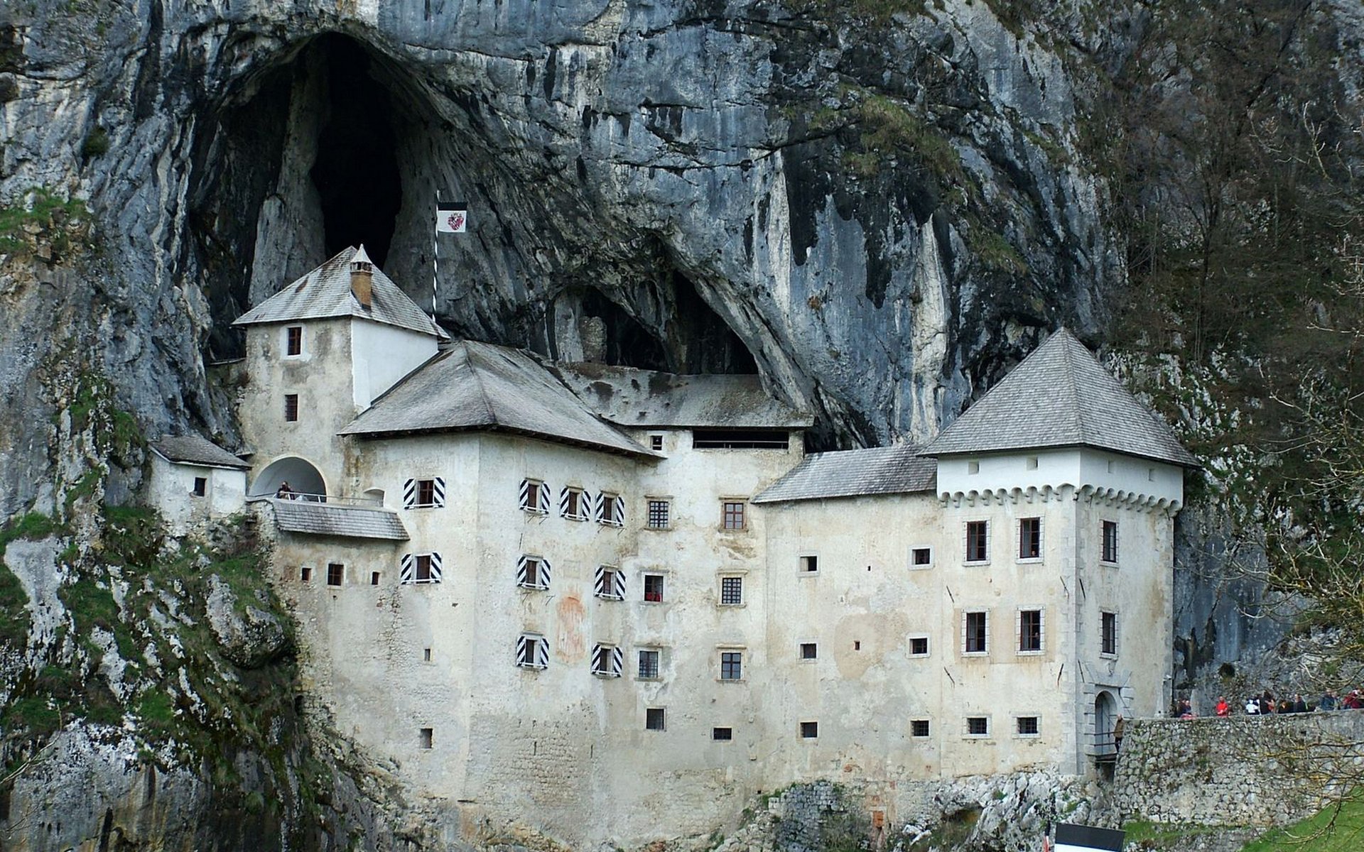 HD PC desktop wallpaper background: Predjama Castle, a man-made medieval fortress nestled inside a cliff cave.