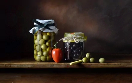 HD PC desktop wallpaper featuring jars of green and black olives alongside a small red pepper on a wooden surface with a dark, moody background.