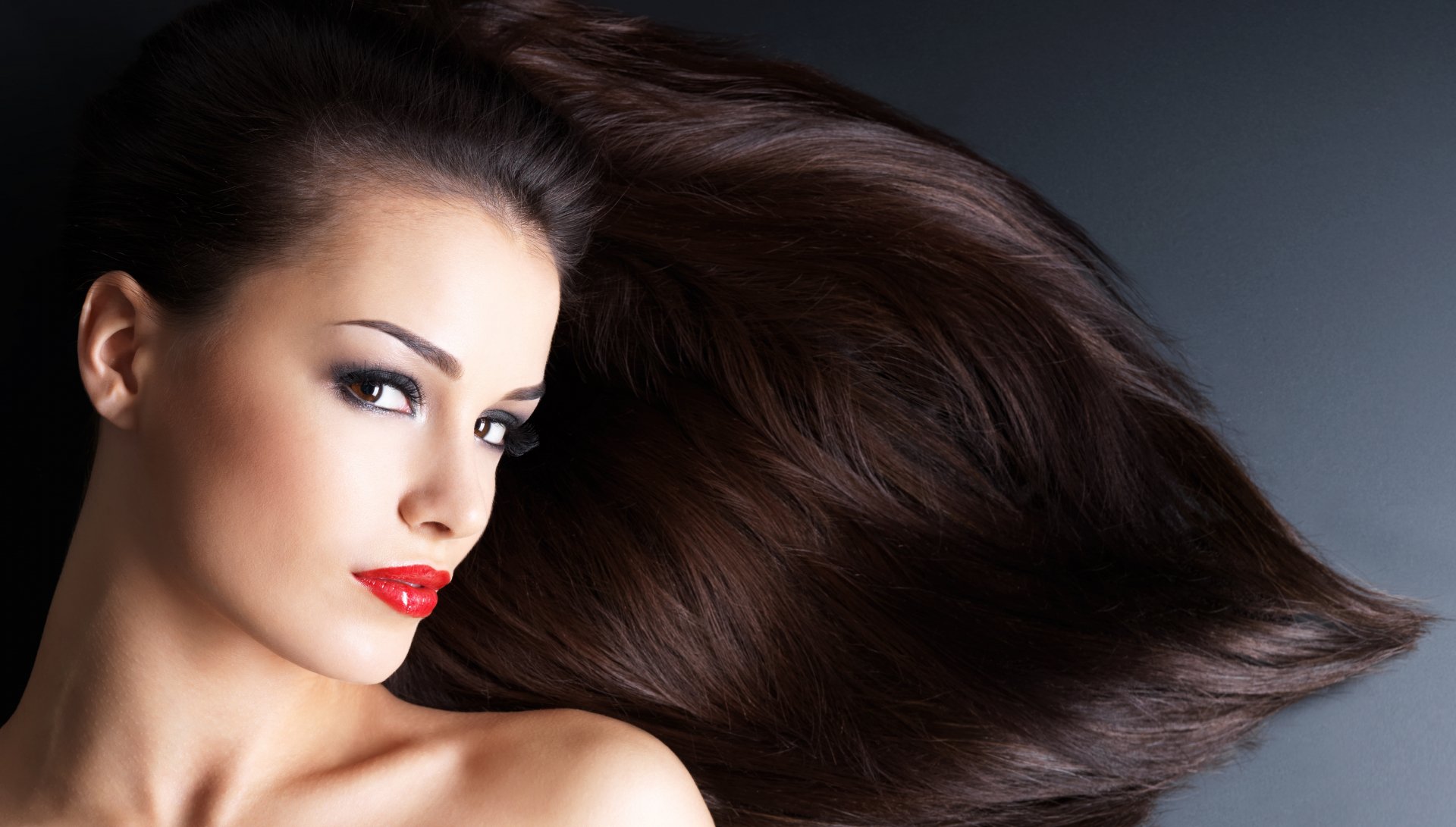 Close-up of a woman with long flowing dark hair and red lipstick, featured in a 4K Ultra HD PC desktop wallpaper background.