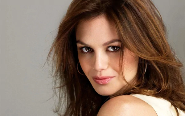 HD desktop wallpaper featuring a close-up portrait of brunette celebrity Rachel Bilson with soft makeup and loose hair against a neutral background.