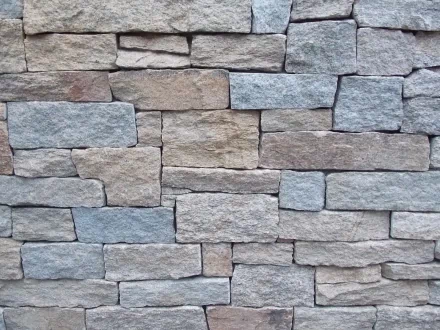 HD desktop wallpaper featuring a man-made stone wall composed of slate and brick arranged in an interlocking pattern.