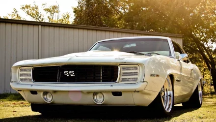 HD PC desktop wallpaper featuring a classic white Chevrolet Camaro SS parked outdoors with sunlight highlighting its sleek design.