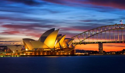 HD desktop wallpaper showcasing Sydney Harbour at dusk, featuring the illuminated Sydney Opera House and Sydney Harbour Bridge in Australia.