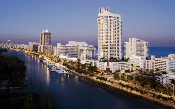 A vibrant Miami Beach skyline in Florida at dusk, featuring man-made waterfront buildings and illuminated streets, captured in an HD PC desktop wallpaper.