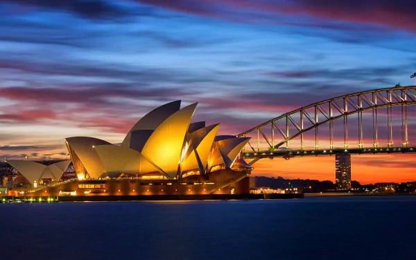 HD desktop wallpaper showcasing Sydney Harbour at dusk, featuring the illuminated Sydney Opera House and Sydney Harbour Bridge in Australia.
