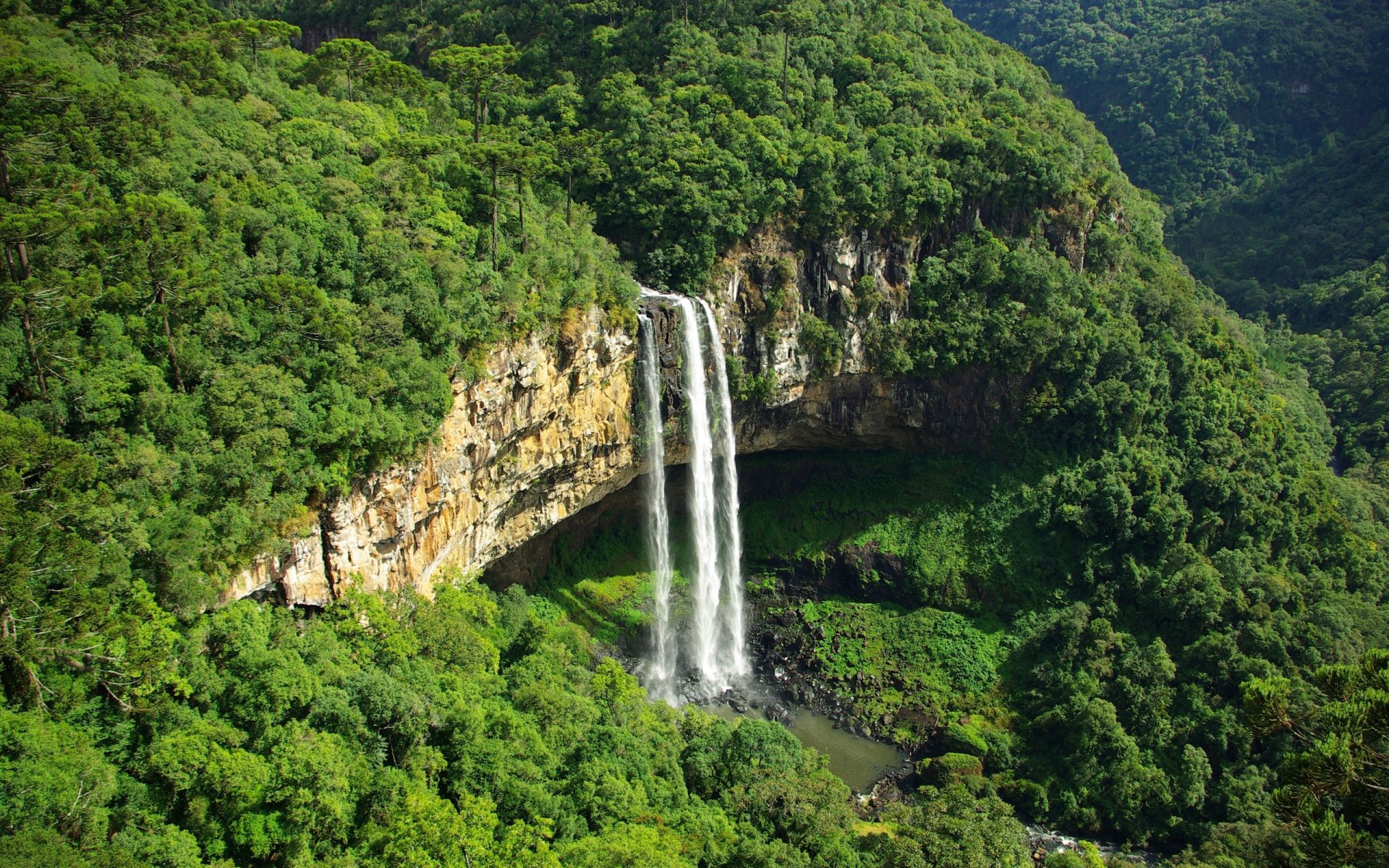 Lush green valley with Caracol Falls cascading from a cliff into a pool; panoramic nature scene rendered as a 2K Quad HD PC desktop wallpaper and background.