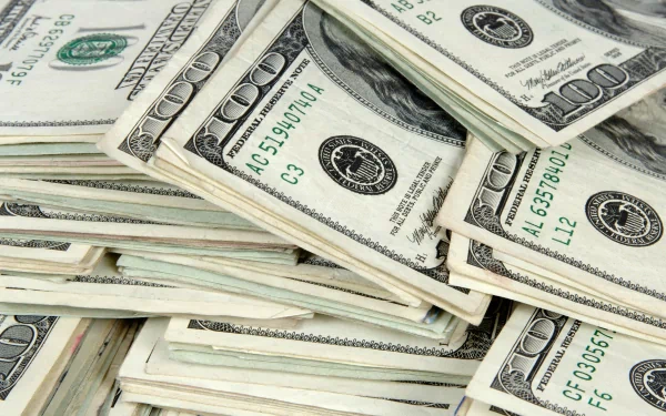 HD desktop wallpaper featuring close-up stacks of man-made US dollar bills, emphasizing detailed currency design and texture.