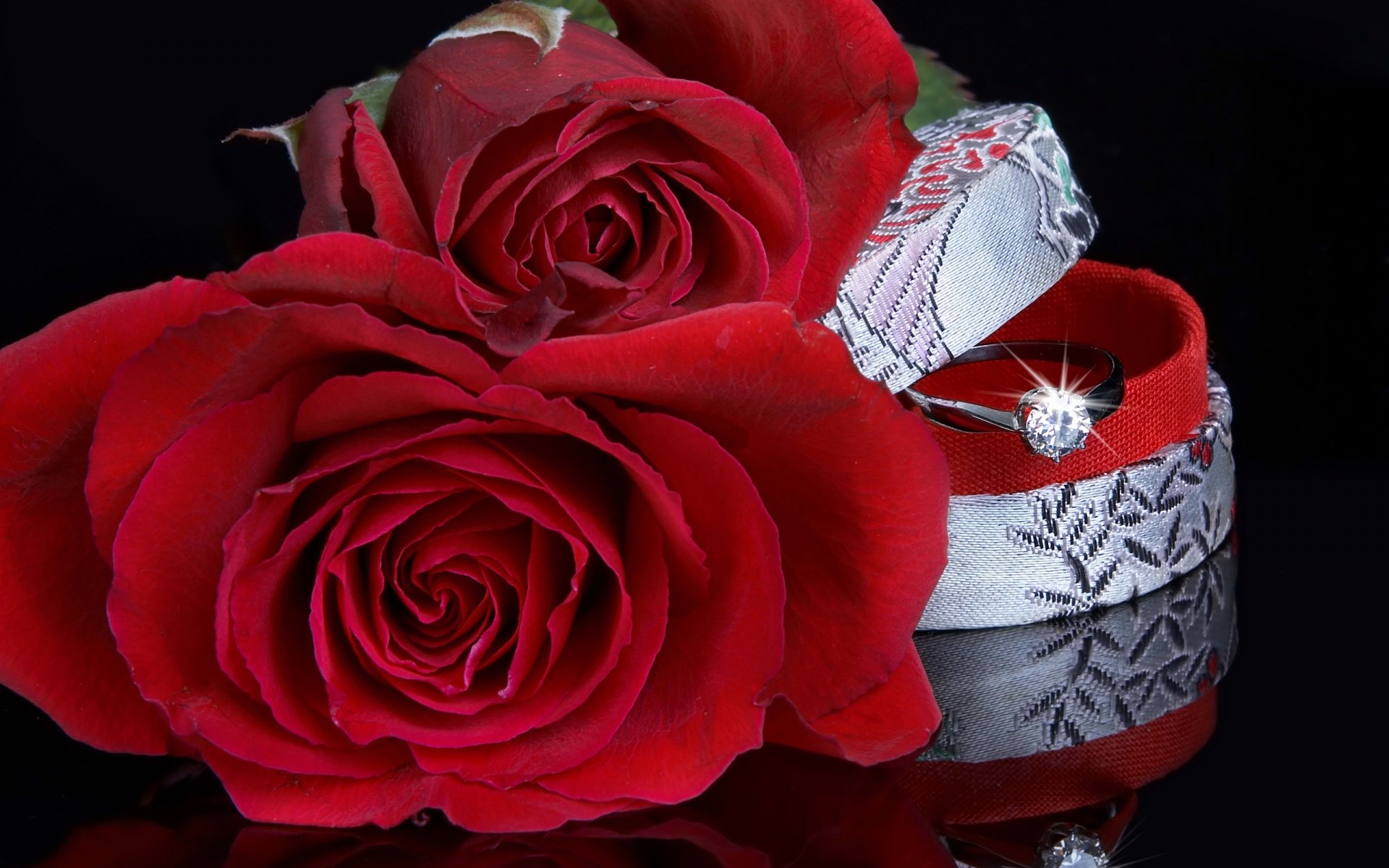 HD desktop wallpaper featuring a sparkling wedding ring nestled beside vibrant red roses, capturing the essence of love, holiday, and celebration.