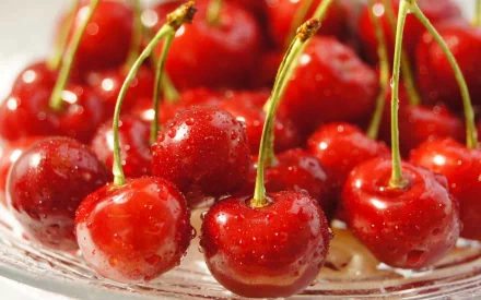 HD PC desktop wallpaper featuring a close-up of fresh, glistening red cherries with water droplets, showcasing vibrant food imagery.