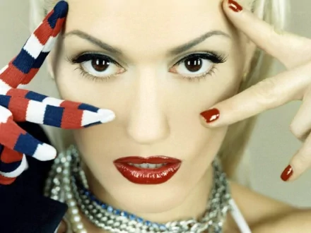 HD PC desktop wallpaper featuring a close-up of Gwen Stefani with bold makeup and red, white, and blue painted fingers, blending music and vibrant style.