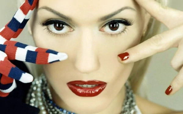 HD PC desktop wallpaper featuring a close-up of Gwen Stefani with bold makeup and red, white, and blue painted fingers, blending music and vibrant style.