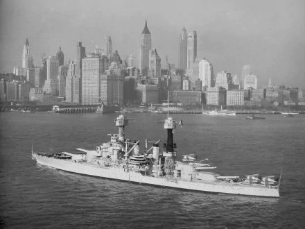 Black and white HD wallpaper of the USS Colorado (BB-45) battleship sailing with the United States Navy against a city skyline backdrop.